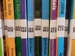  Photo of books on a shelf. Focus is on the spine label with the Dewey Decimal number.